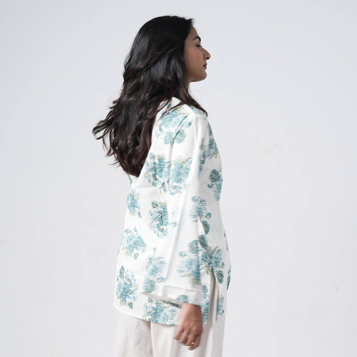 Back view of aqua blue floral short kurti with blue rose prints on a white base