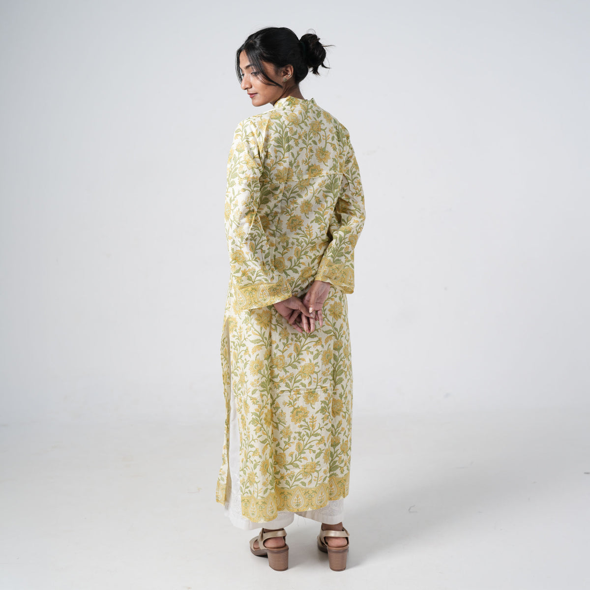 Back view of Haldi Baagh long kurti with yellow floral prints and green leafy patterns