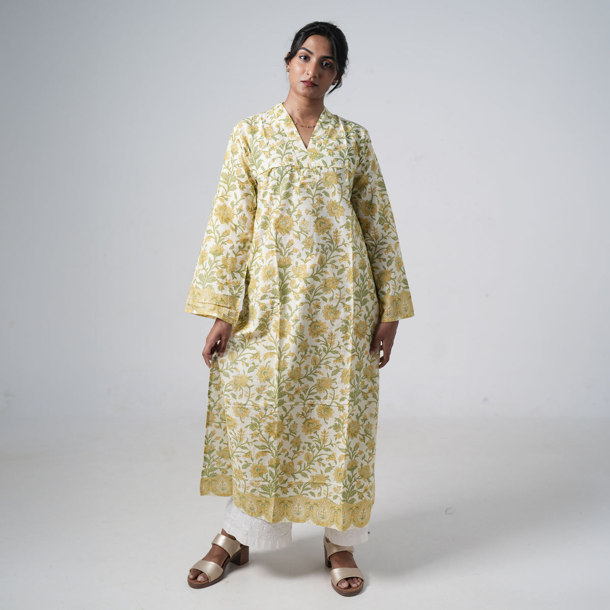 Haldi Baagh long kurti for women with yellow floral prints and green leafy patterns on a cream base