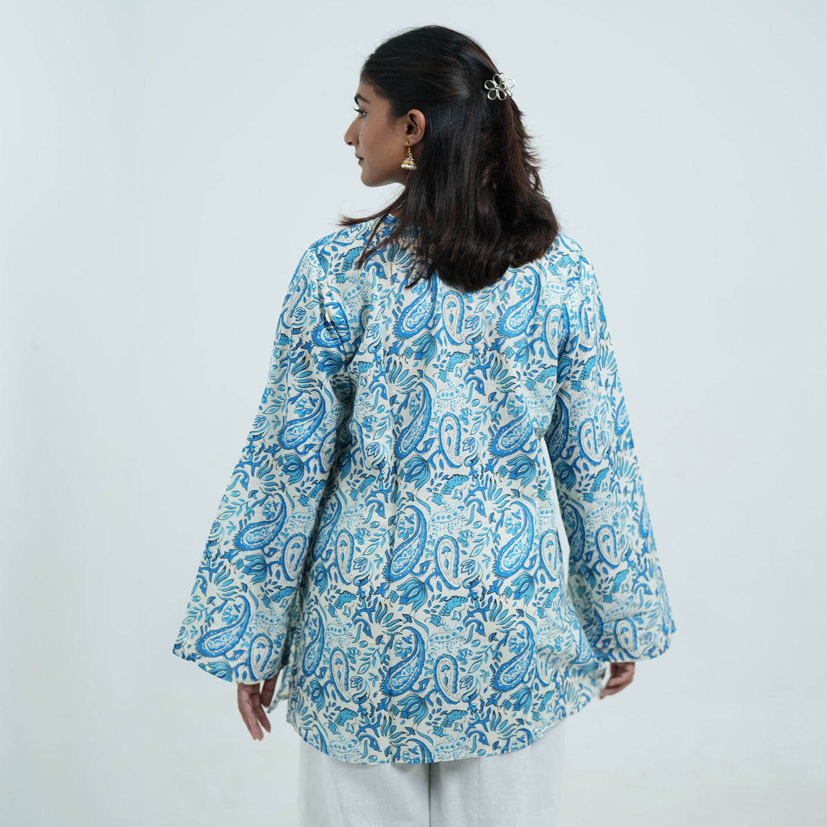 Back view of Neelam Noor Short Kurti featuring a white base, blue paisley print and long flared sleeves