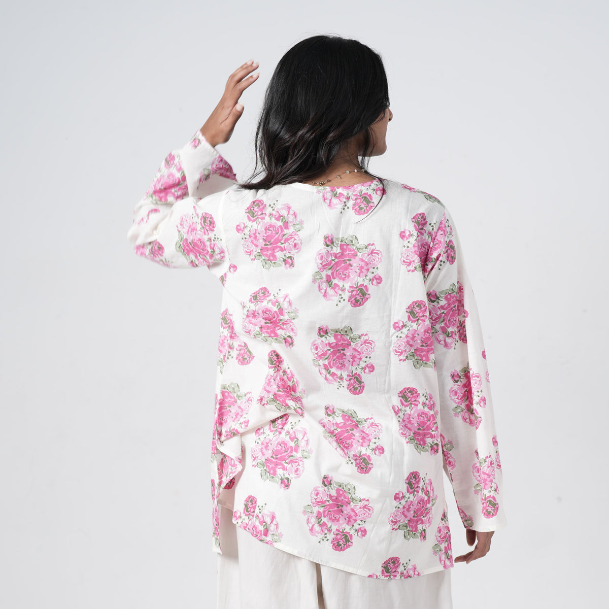 Back view of pink floral short kurti with pink rose prints on a white base