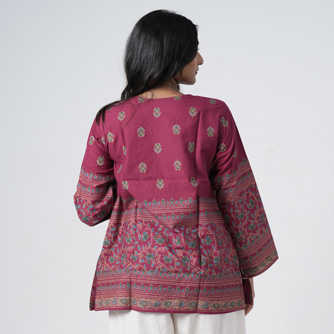 Back view of Ruby Short Kurti featuring ruby pink fabric with floral motifs and decorative patterned borders