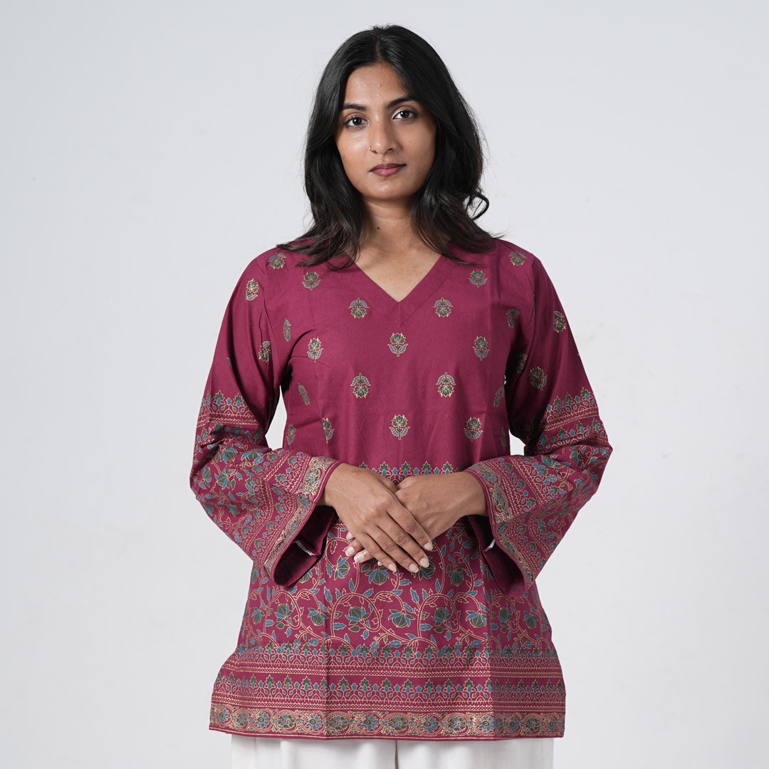Ruby Short Kurti for women in ruby pink with small floral motifs, a V neckline and decorative multicolour border prints