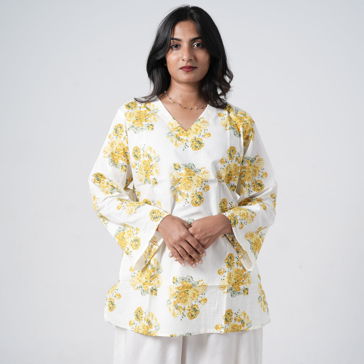 Yellow floral short kurti for women with yellow rose prints on a white base
