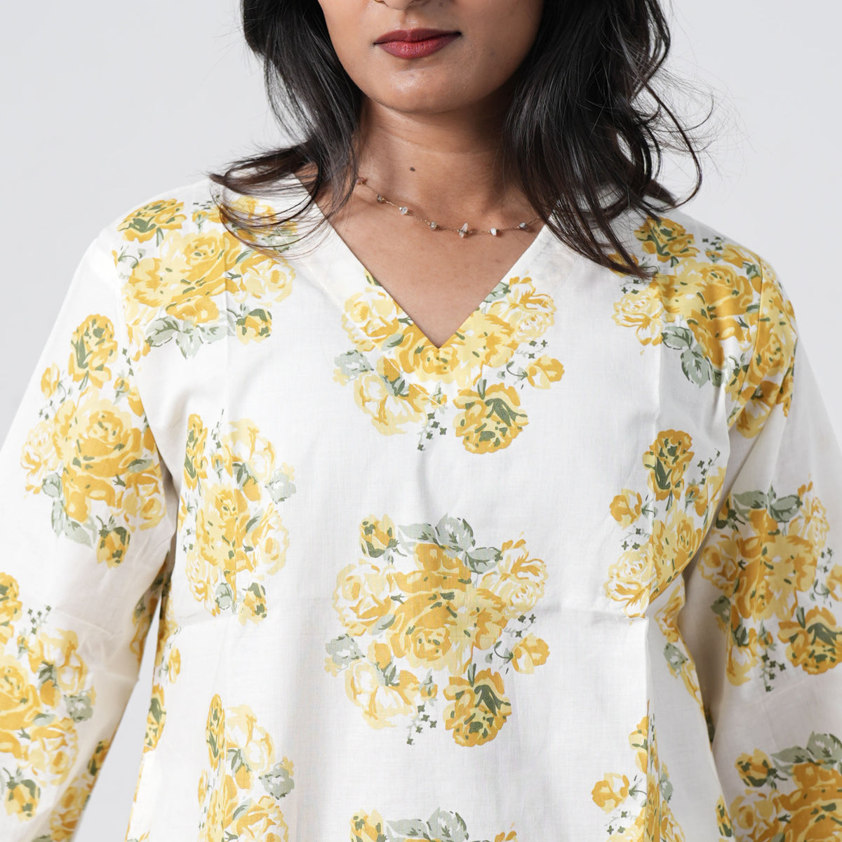 Yellow floral short kurti featuring a V neckline and yellow rose patterns