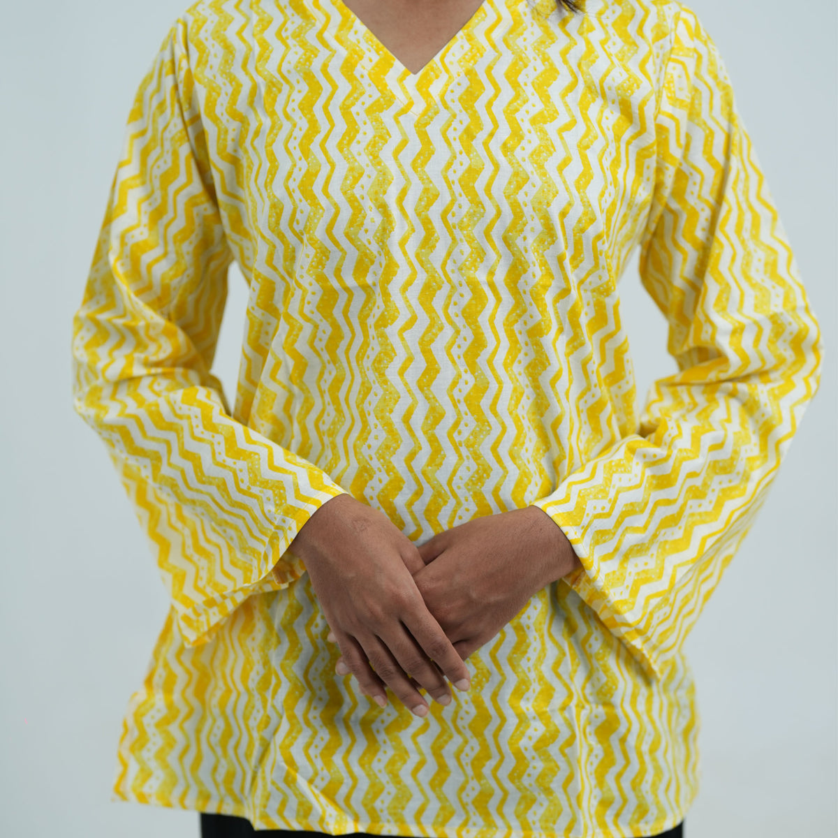 Yellow Short Kurti featuring long sleeves with a yellow and white zigzag pattern