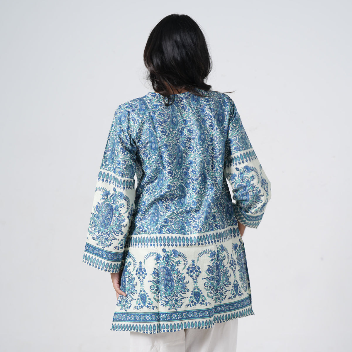 Back view of Zareen Knee Kurti featuring cream fabric with blue paisley prints and decorative borders