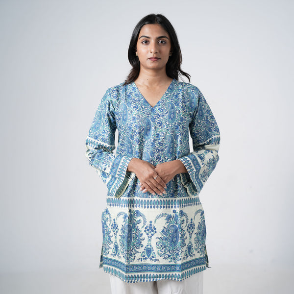 Zareen Knee Kurti for women in cream with intricate blue paisley prints, a V neckline and decorative border patterns